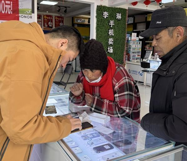 李琳在教到店购机的农村老人使用智能手机。受访者供图
