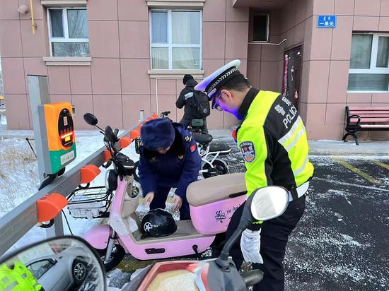 现场执法人员正在挪动占用消防通道电动自行车。欧登 摄