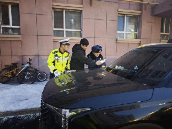 现场执法人员正在通知占用消防通道车主挪车。欧登 摄