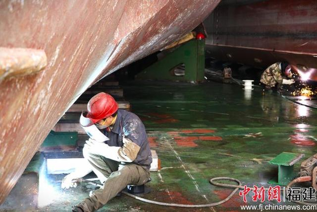 图为“华瑞龙”轮上的工人正进行运输船舶绑扎加固件的焊接工作。吴允杰 摄
