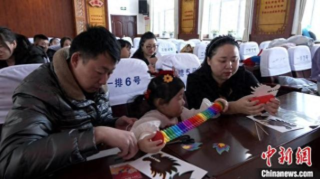 家长带着孩子进行“国潮舞龙”手工制作。 王婷 摄