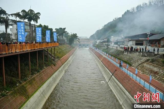 青衣江水从东风堰闸门奔涌而出流向远方，水渠边站满了围观的群众。记者 刘忠俊 摄