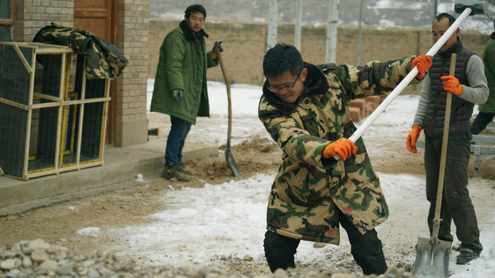 穿着迷彩服在工地干活的老赵。受访者供图