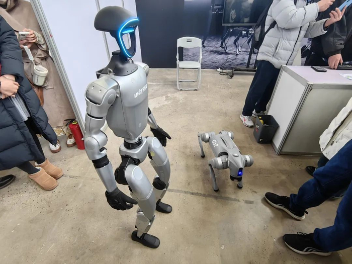 图为：宇树科技人形机器人现场遛机器狗  来源：中国基金报记者邱德坤拍摄