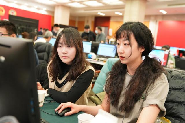 3月6日，我（前左）和同事刘梦琪在后方两会新闻报道中心工作。新华社记者 陈朔 摄