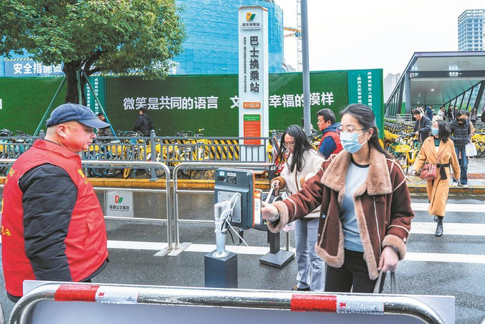     乘客在站台上刷卡。