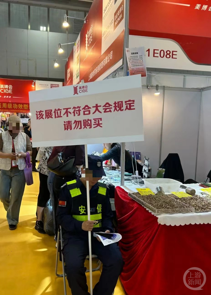 广州美博会现场，保安举牌警示“请勿购买”。网络图