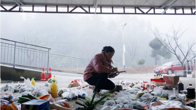 ▲司机送到货物后，王义琴会认真为每个顾客分拣好货物。阳宇 | 摄