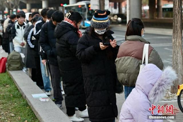 资料图：2025年国考考点外，考生抓紧时间复习。中新社记者 易海菲 摄