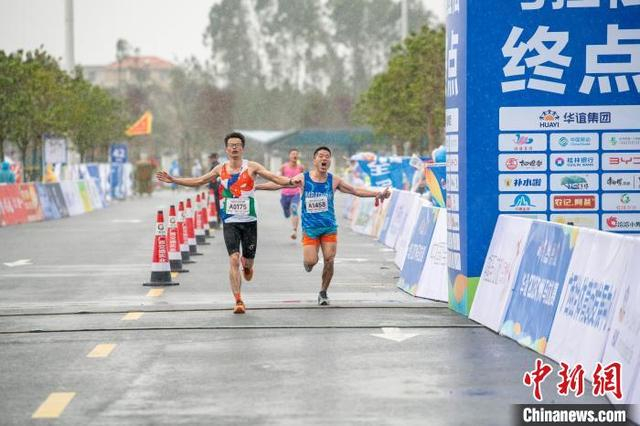 图为参赛选手完成42.195公里的赛程，越过终点。中新社记者 翟李强 摄