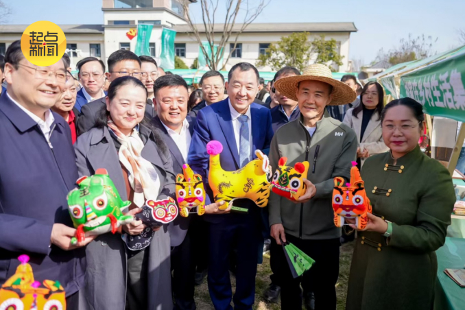 现场嘉宾与非遗手工布偶合影。