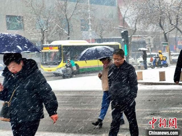 图为民众打伞出行。中新社记者 王小军 摄