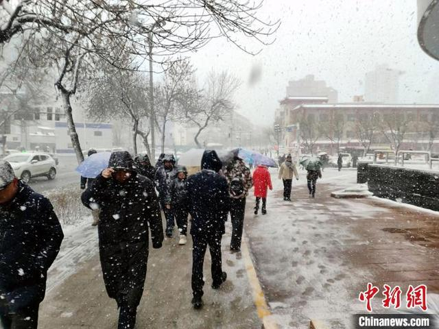 图为民众冒雪上班。中新社记者 王小军 摄