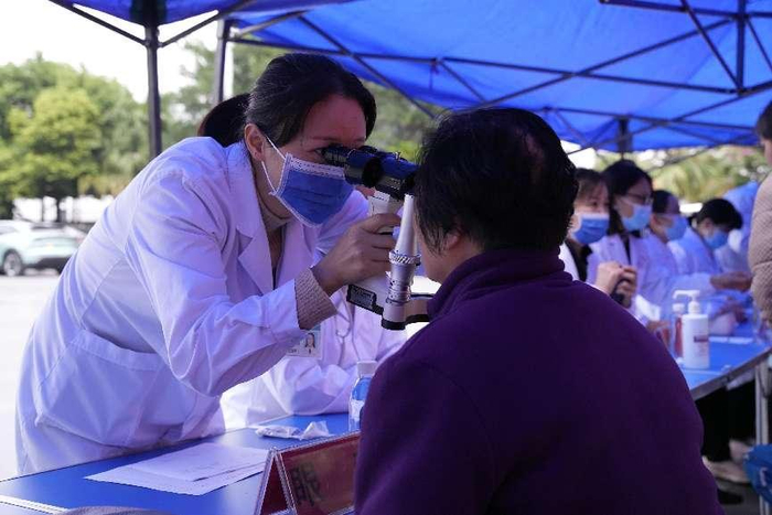  南海区人民医院帮扶专家在义诊现场给群众进行眼部检查 