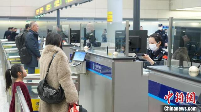 虹桥边检站民警为出入境旅客办理通关手续。顾维依 摄