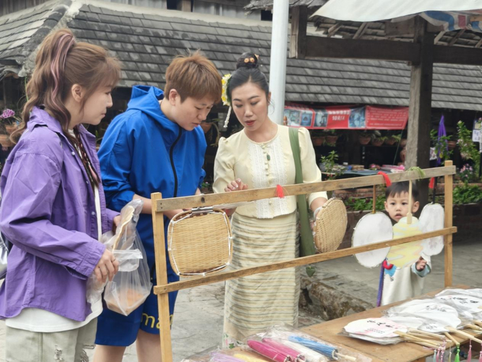 玉发罕在向游客介绍傣家造纸工艺品
