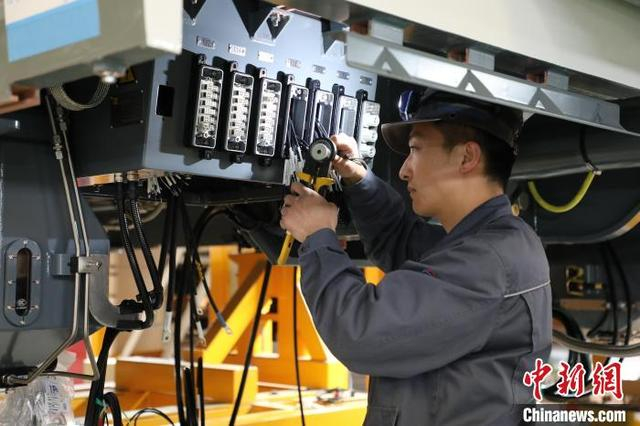 图为京投装备河北京车智能制造基地组装车间内，工人忙着接线作业。南双双 摄