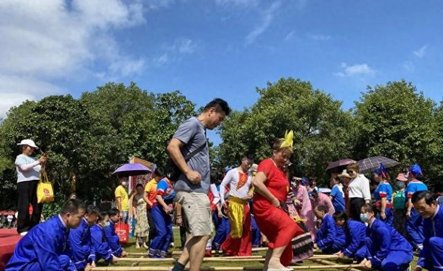 ▲游客体验竹竿舞（资料图）。青秀山风景区供图