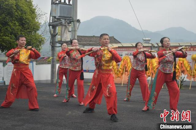 图为江西宜黄县中港镇何坊畲族村内，村民们正在表演宜黄禾杠舞。巫发阳 摄