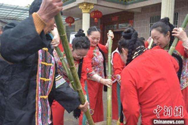 图为3月31日，农历三月初三，江西宜黄县中港镇何坊畲族村内，畲族、汉族村民正在合力打糍粑。巫发阳 摄