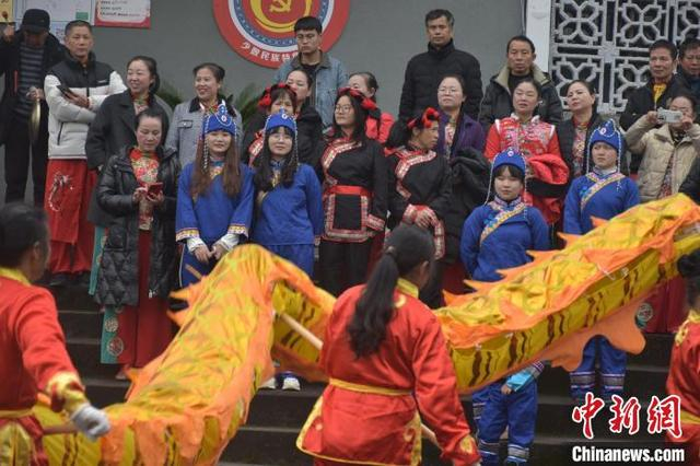 图为江西宜黄县中港镇何坊畲族村内，畲族、汉族村民正在观看舞龙表演。巫发阳 摄