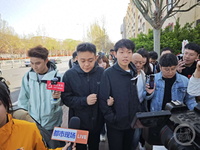 姜甲儒（深色上衣居右者）和哥哥即将进入法庭。上游新闻记者 崔涛 摄