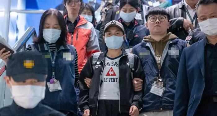 陆配“小微”（右三）在“移民署”人员陪同下前往登机口