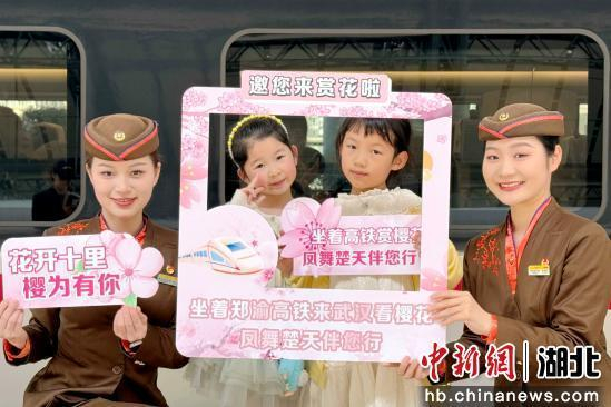 图为武汉客运段列车员与外出赏花的小旅客互动。成华 摄