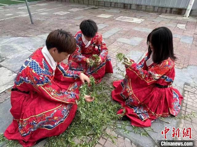 资料图：清明时节，山西大学内多名学子身着汉服，折枝戴柳，挽弓搭箭，再现“清明射柳”这一古老习俗。 郭芃成 摄