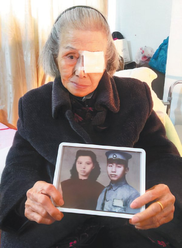 九十三岁的张淑英拿着与亡夫钟崇鑫的合成照