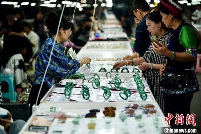 德龙国际珠宝城成品区，游客正在挑选非洲翠和翡翠手镯。 中新网记者 刘冉阳 摄