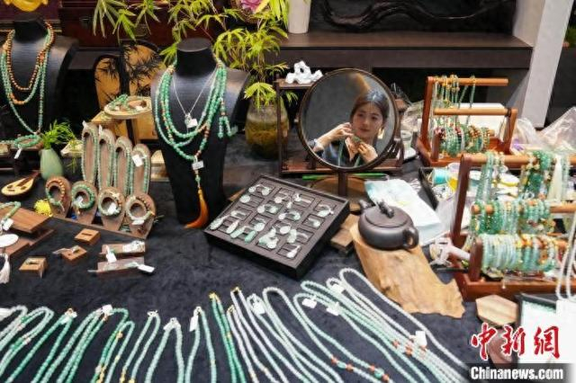 顾客在瑞丽珠宝翡翠艺术馆中挑选非洲翠项链。中新网记者 刘冉阳 摄