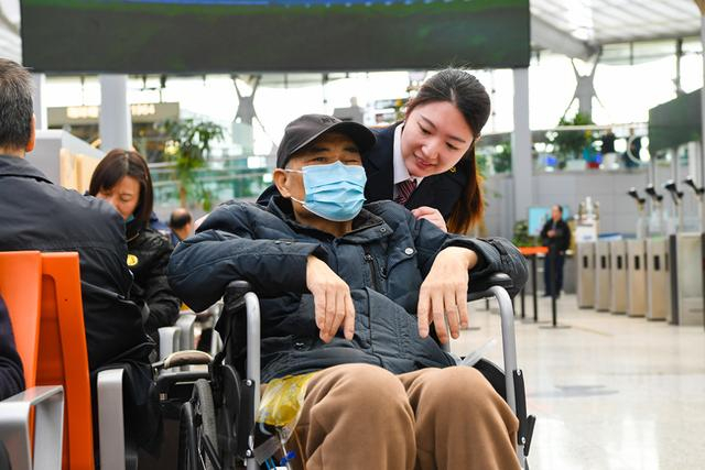 上海南站工作人员服务老年旅客出行。 庄秋冬 图