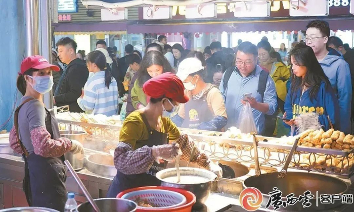 市民和游客在侨港风情街排队选购特色虾饼。广西云-广西日报记者 覃鸿图 摄