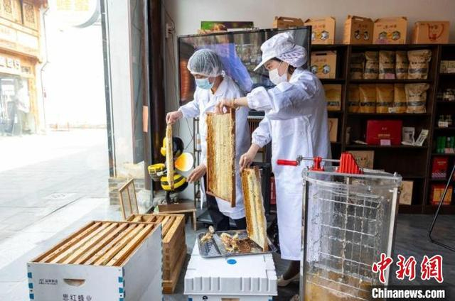 图为店员正在处理蜂蜜。乐平市融媒体中心供图