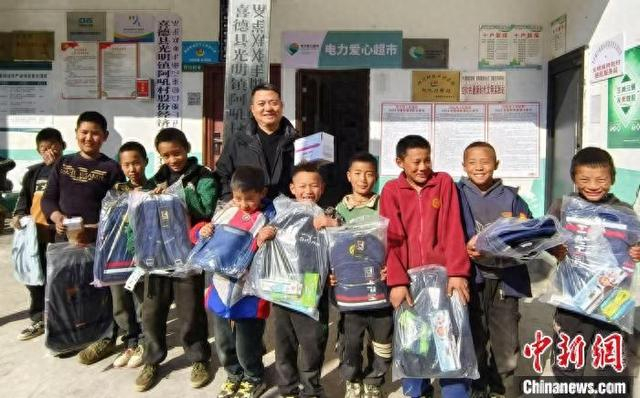 2025年2月，王小兵在阿吼村给孩子发放学习用品。受访者供图