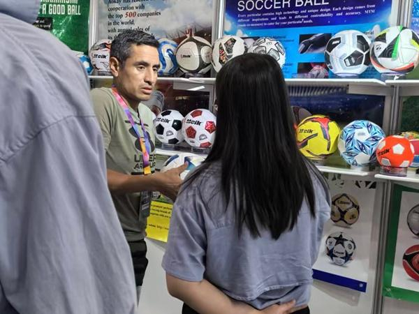 今年3月底，吴晓明带着自家品牌到巴拿马参展，图为展位工作人员正在与前来参观的客商交谈。受访者供图