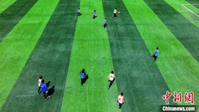 4月13日，青海玉树藏族自治州曲麻莱小球员在青少年足球训练基地内踢球。 薛蒂 摄