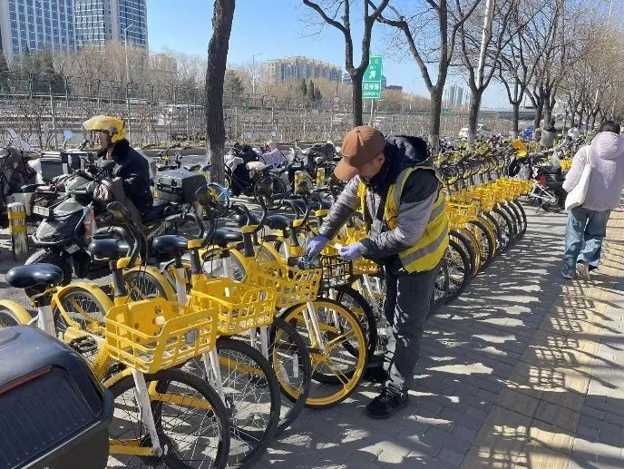 美团单车运维团队在清理车身小广告。（受访单位供图）