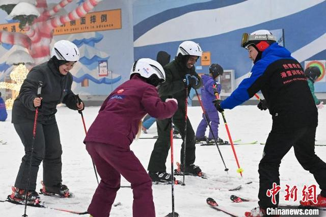4月19日，云南昆明，留学生在教练的指导下学习滑雪。中新社记者 李嘉娴 摄 