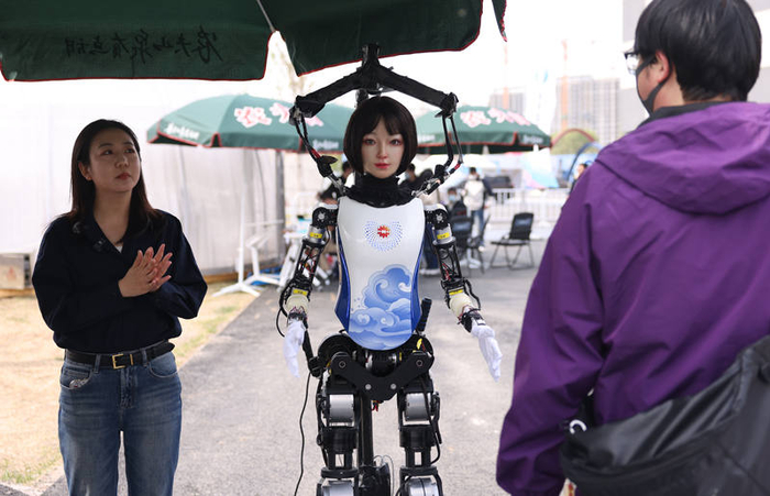 钢宝队工作人员在介绍美女机器人“幻幻”。新京报记者 李木易 摄