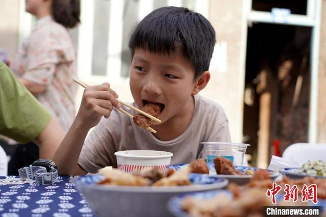 图为一位小朋友正常开心地品尝特色圆子。中新社记者 吕杨 摄