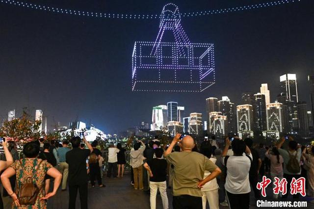 图为民众观看无人机表演。中新社记者 何蓬磊 摄