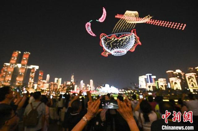 图为民众观看无人机表演。中新社记者 何蓬磊 摄