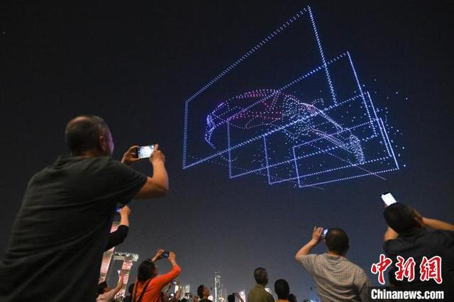 图为民众观看无人机表演。中新社记者 何蓬磊 摄