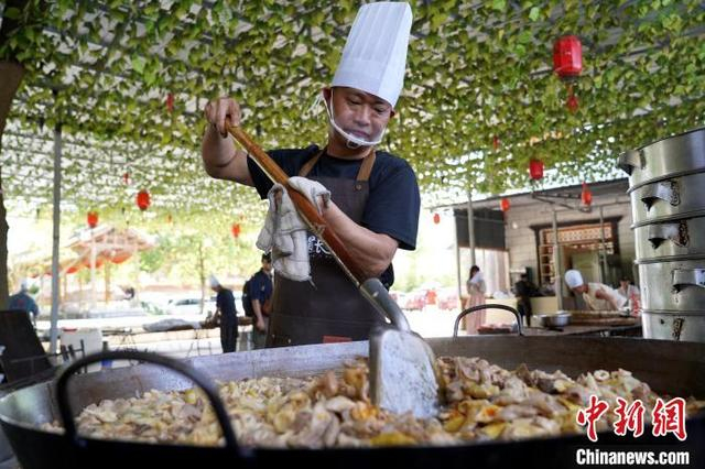 图为厨师正在大锅炒制美味菜肴。中新社记者 吕杨 摄