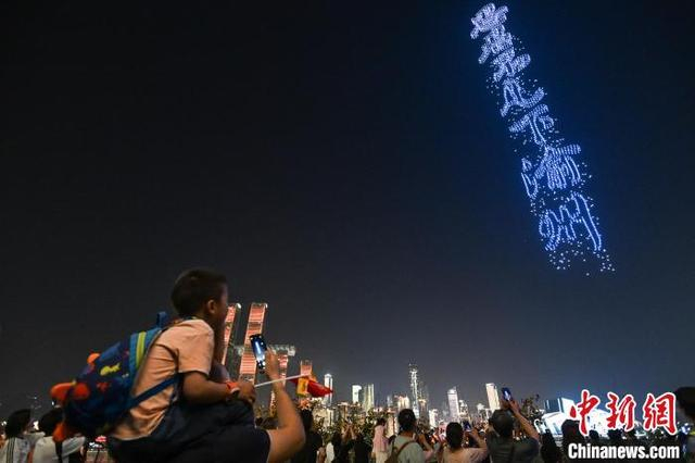 图为民众观看无人机表演。中新社记者 何蓬磊 摄