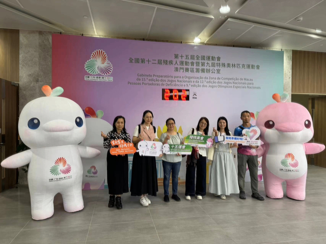 图为参加培训的澳门赛区部分志愿者在倒计时牌前，与赛事吉祥物合影。（记者富子梅摄）
