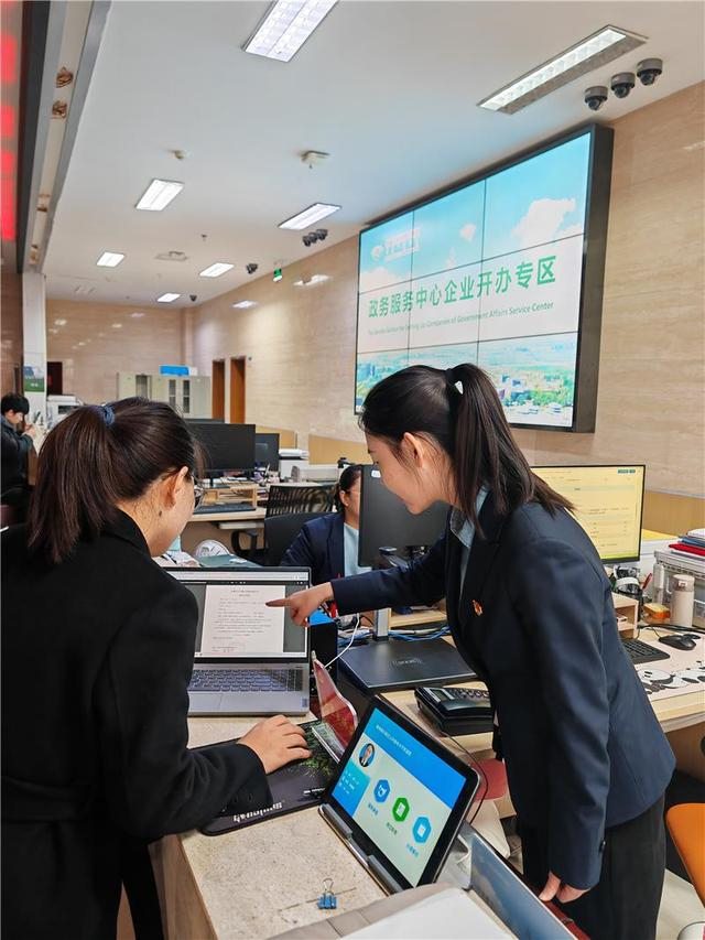 工作人员指导帮助办事群众办理业务。（资料图）