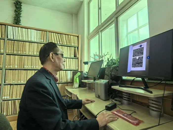 在甘肃省图书馆盲文及盲人有声读物阅览室，视障读者常伟正在通过智能纸质图书阅读器听书。新华社记者任延昕 摄